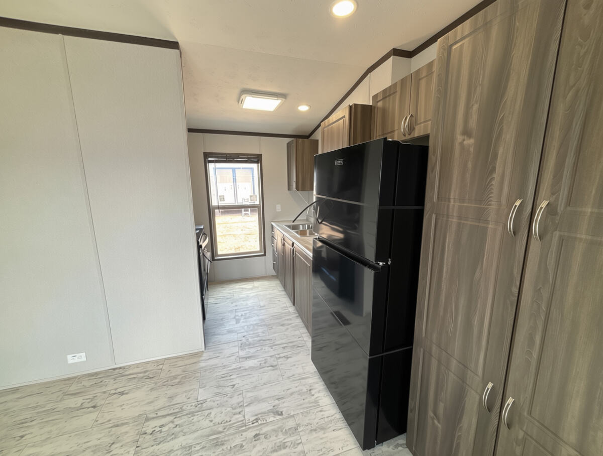 Gabinetes, barra y fregadero de cocina dentro de una unidad de vivienda H-2A de Vida Casita